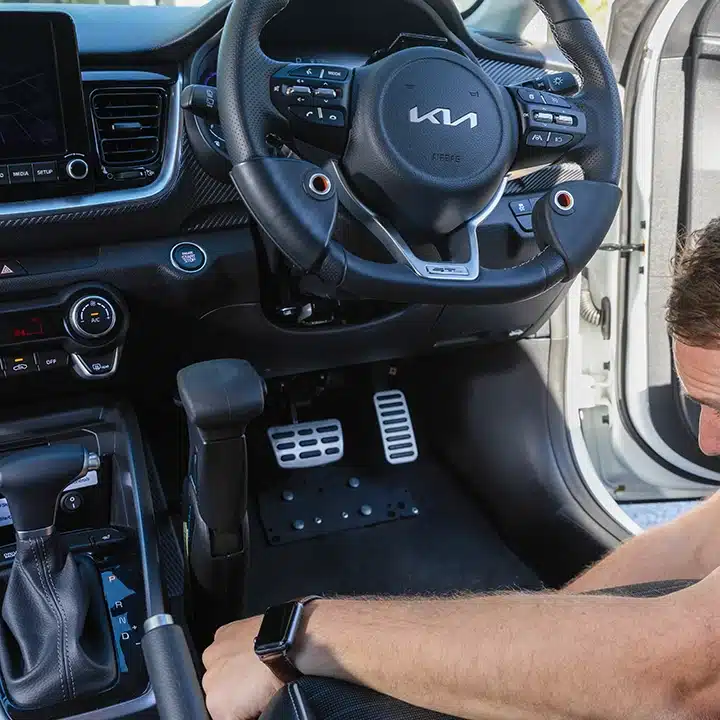 Adapted steering wheel and modified foot pedals in an accessible driving training vehicle.