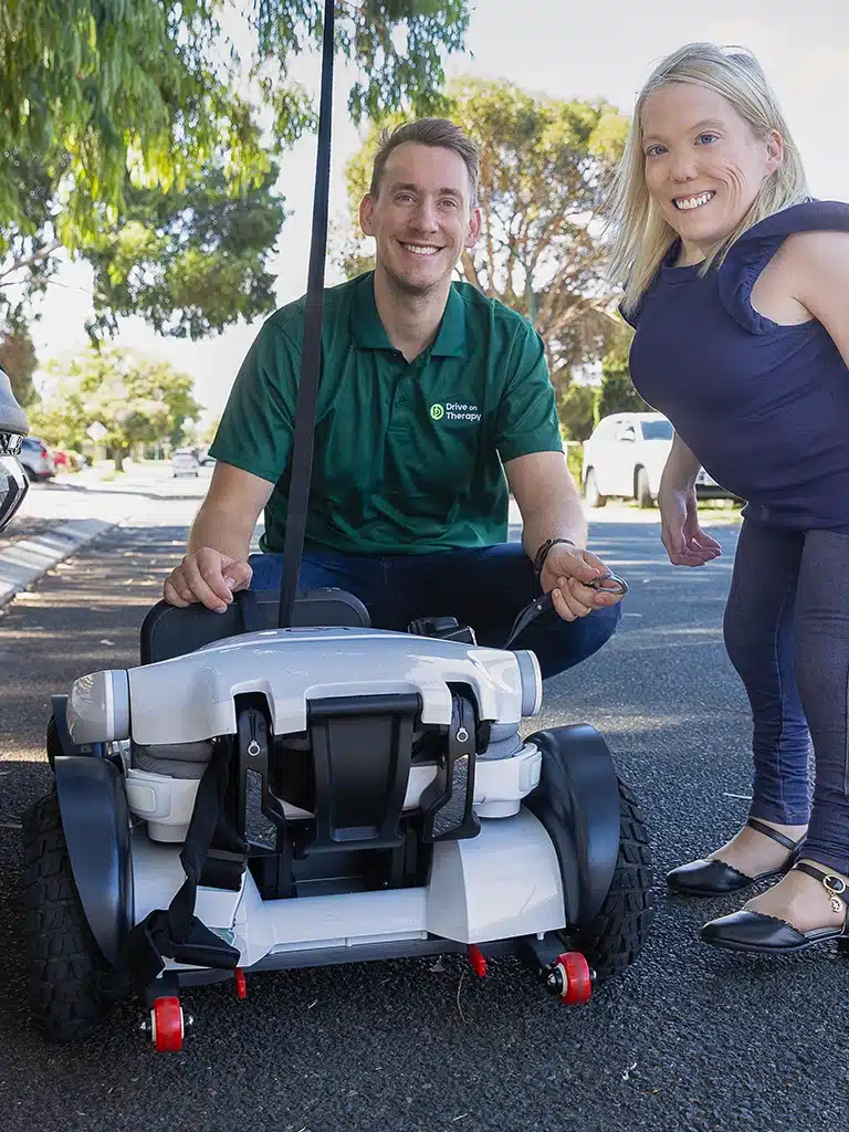 Drive On Therapy specialist and client preparing a portable electric wheelchair for vehicle access.