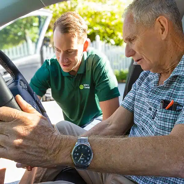 Occupational therapist from Drive On Therapy assisting an older man during a vehicle-based driving assessment.