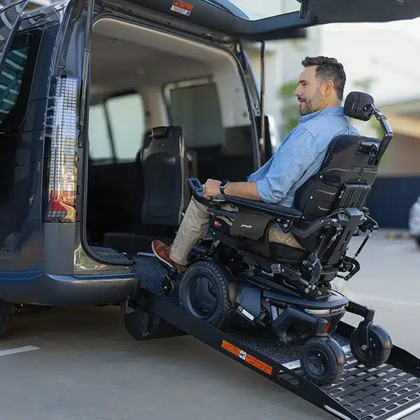 Man in a power wheelchair entering an adapted van, symbolising return to driving with modifications.